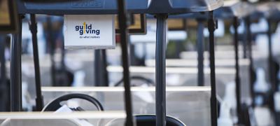 Golf carts lined up labeled with Guild Giving logo